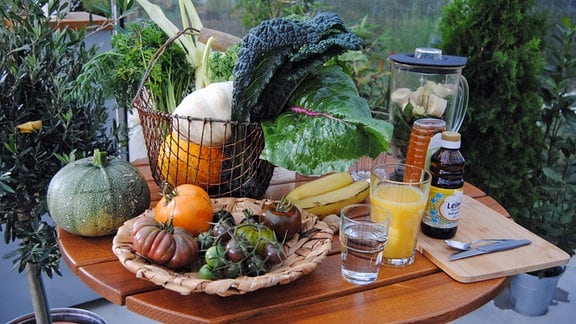 Gemüse, Saft und Öl als Zutaten für Fitness-Smoothie auf Tisch