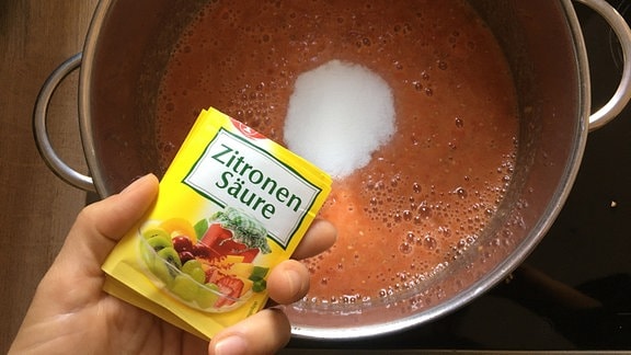 Zitronensäure in Topf mit pürierten Tomaten