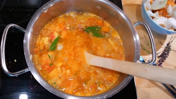 Tomaten und Gewürze werden in einem Topf aufgekocht