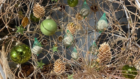 Große Kugel aus Weidenruten mit Weihnachtskugeln, Tannenzapfen und Futterkugeln mit Vogelfutter.