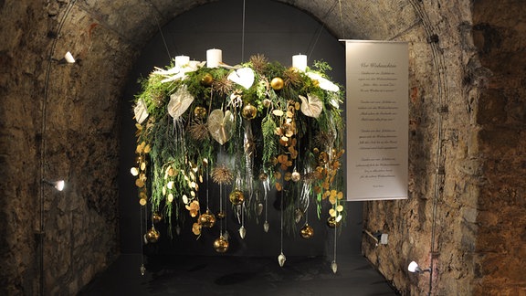 Großer, aufgehängter und üppig dekorierter Adventskranz in der Ausstellung Florales zur Weihnachtszeit im Erfurter Domfelsenkeller 2022.