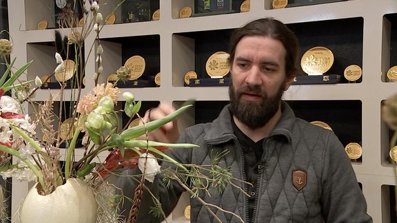 Floristmeister Christopher Ernst mit einem Ostergesteck
