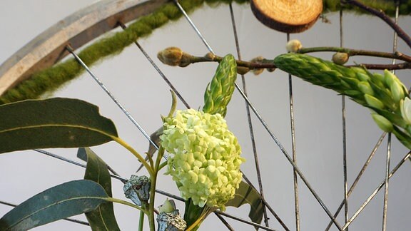 Fahrrad-Felge mit Deko aus Blumen und Zweigen