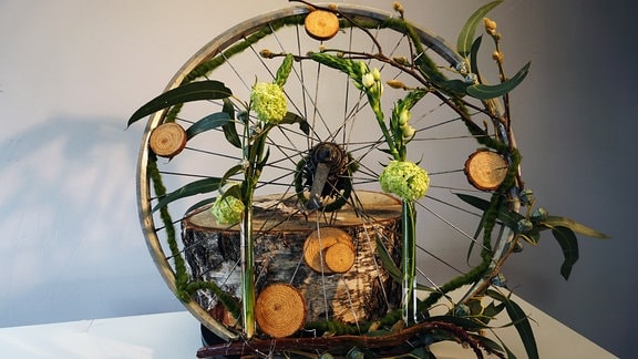 Fahrrad-Felge mit Deko aus Blumen und Zweigen