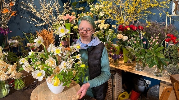Eine Florstin arbeitet an einem Blumengesteck.