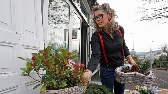 Floristin Franziska Rühle stellt Pflanzen vor ihren Laden