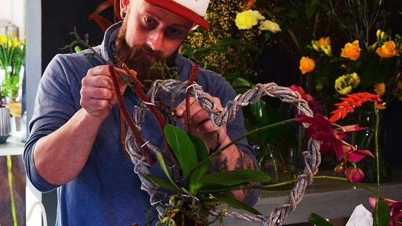 Florist Rocco Wustmann dekoriert geflochtenes Herz  