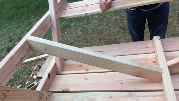 Blick auf eine Holzkonstruktion mit einem stabilisierenden Querbalken.