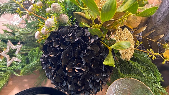 Tisch-Deko mit schwarz gefärbter Hortensie und grünen Zweigen