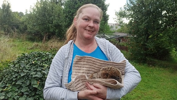 Sandra Reichmann vom Verein Igelherzen Nordthüringen mit einem Igel auf dem Arm.