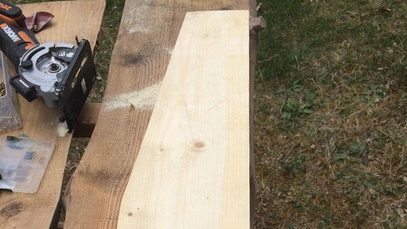 Ein Holzbrett mit Schräge liegt auf einem Tisch.