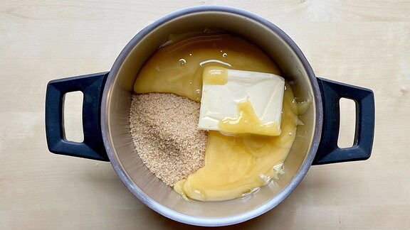 Butter, Honig und Zucker in dem Topf