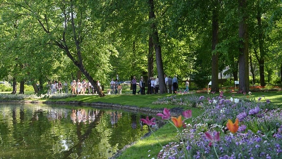 Menschen spazieren durch einen Park. 