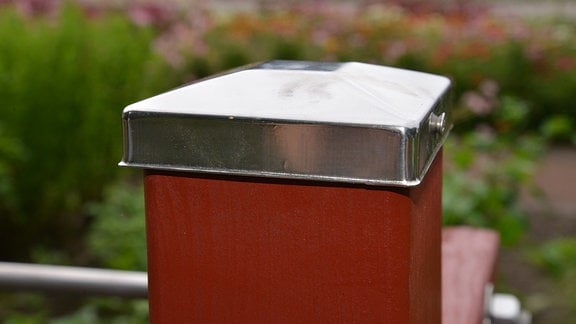 Ein Balken ist mit einer Aluminiumkappe abgedeckt.  