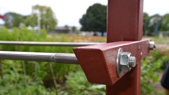 Lange Stahlrohre wurden mit einem Holzbalken verschraubt.  