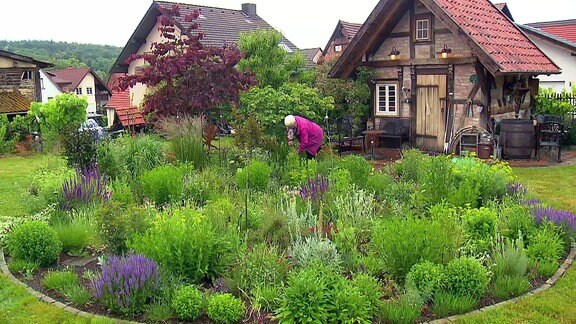 Eine Frau arbeitet in ihrem Garten.
