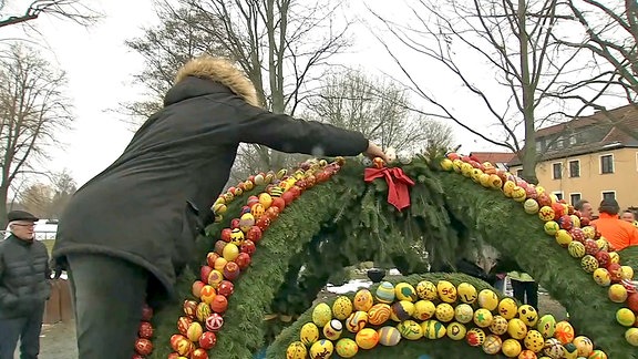 Letzte Handgriffe an der Krone des Osterbrunnens in Langenwetzendorf