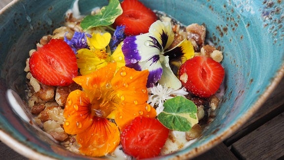 Blüten von Kapuzinerkresse und Hornveilchen auf Joghurt