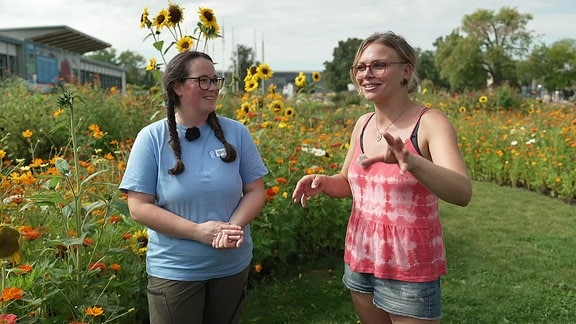 Zwei Frauen vor einer Wiese mit hohen Blumen