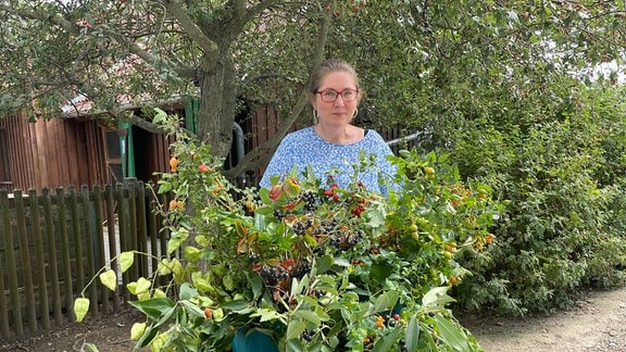 Gartenberaterin Helma Bartholomay steht hinter einem Tisch mit Wildfrüchten im Egapark Erfurt.