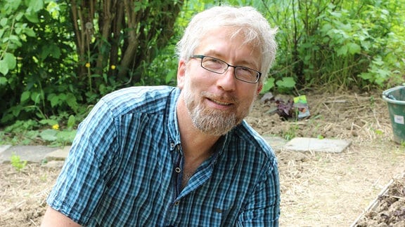 der Redakteur Jörg Heiß pflanzt eine Rosenkohl-Jungpflanze