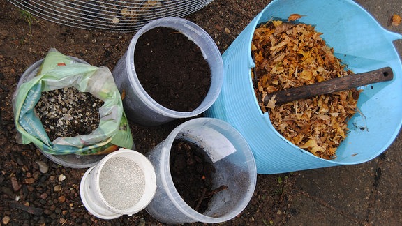 Eimer aus Kunststoff mit Kompost, Laub, Erde und weiteren Zutaten für selbstgemacht Lauberde