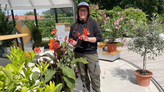 Egapark-Gärtnerin Melanie Trinks steht neben Kübelpflanzen im MDR-Gartenreich.