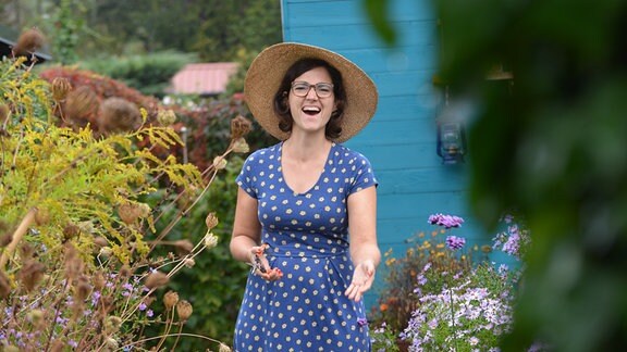 Nadine Witt steht in dem Garten und lacht.
