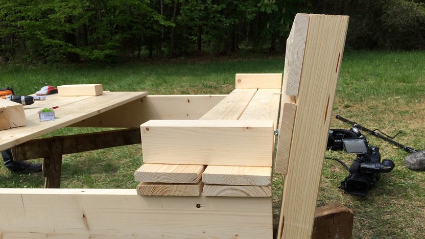 How Do You Build A Sandbox With A Lid And Bench? 3 Blick auf eine Holzkonstruktion mit einer Art Bank.
