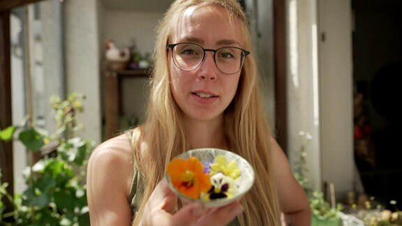 Katharina Koch hält ein Schälchen mit geernteten essbaren Blüten