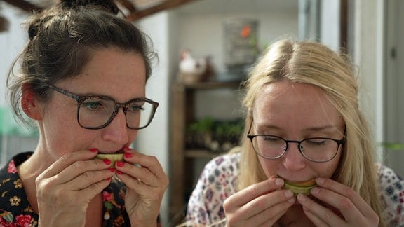 Reporterin Nadine Witt und Balkongärtnerin Katharina Koch beißen in Melonenscheiben