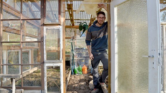 Hobbygärtner Fabian Fröderking steht in seinem selbstgebauten Gewächshaus