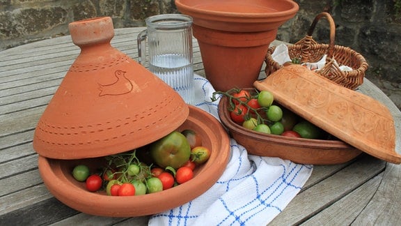 Unreife Tomaten in Tongefäßen mit Deckel. 