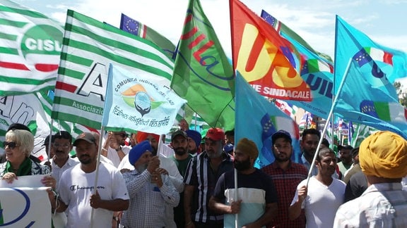 Viele indische Männer mit Fahnen und Plakaten in der Hand