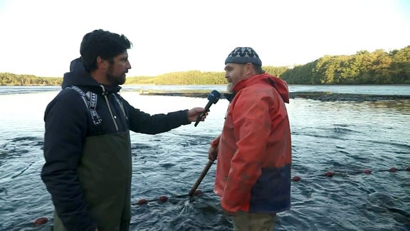 zwei Männer stehen im Wasser und unterhalten sich