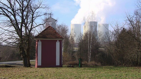 Kühltürme eines Kraftwerks im Hintergrund einer Landschaftsaufnahme