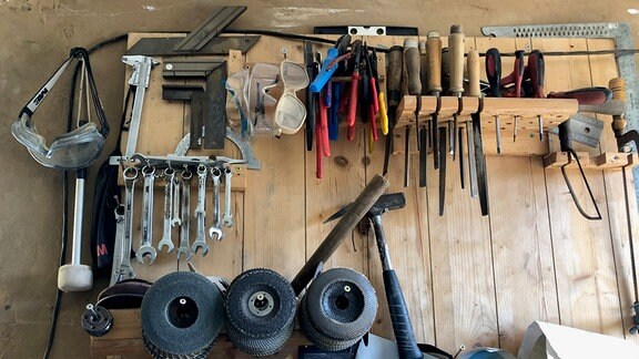 Werkzeuge hängen an einer Wand.