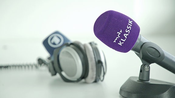 MDR KLASSIK-Mikrofon auf Ständer im Vordergrund, im Hintergrund Kopfhörer und ARD-Mikrofonschutz.