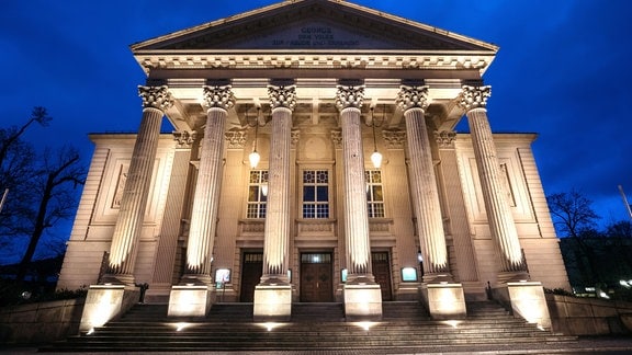 Die Säulenfassade des Meininger Staatstheater wird in der blauen Stunde von Scheinwerfern angestrahlt