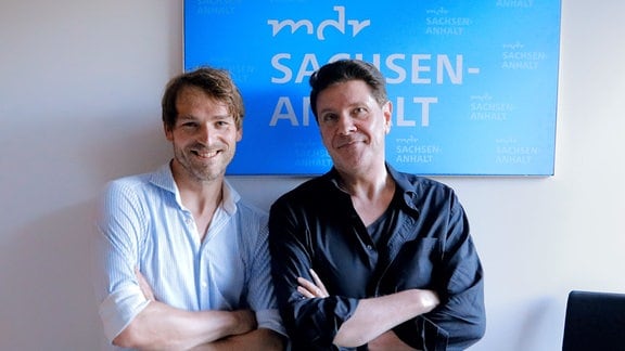MDR-Moderator André Holst steht gemeinsam mit Sänger Friedrich Rau in einem Radiostudio.