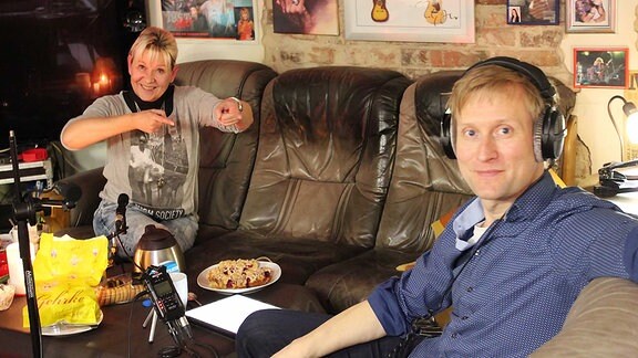 Heike Huth und Tobias Kluge bei Interview mit Kaffe und Kuchen auf einer Couch