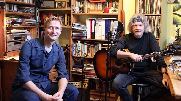 Tobias Kluge und Liedermacher Paul Bartsch sitzen in seinem Arbeitszimmer