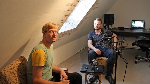 Interview mit zwei Männern auf Sesseln in kleinem Tonstudio auf Dachboden