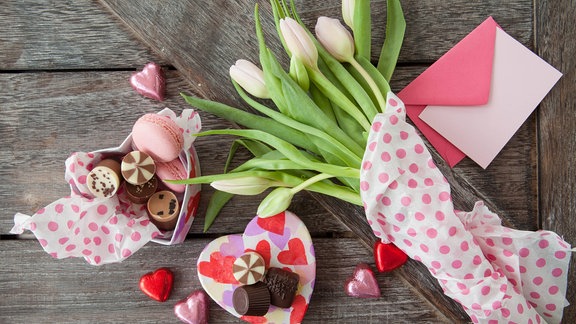 Herzschachtel mit Schokolade, Tulpen und ein Brief