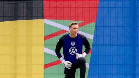 Torwart Jan Reichert dehnt sich vor dem Logo der UEFA EURO