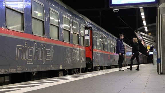 Menschen stehen vor einem blauen Waggon mit der Aufschrift "Nightjet"