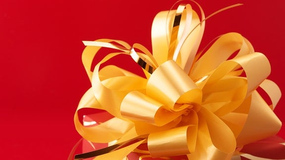 Eine gelbe Schleife auf einem roten Geschenk