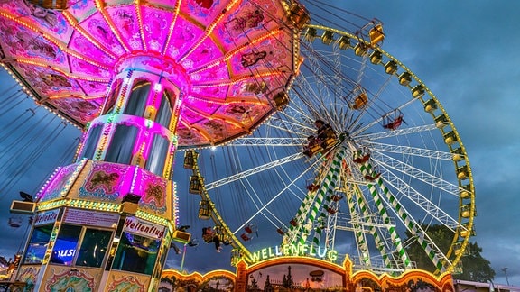 Riesenrad und historiches Kettenkarussell bei einem Volksfest 