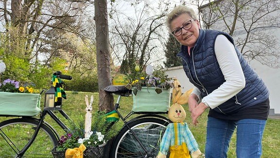 eine Frau neben einem geschmückten Fahrrad