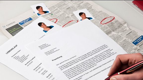 Imagebild: Bewerbung - Lebenslauf und Bewerbungsabschreiben liegen neben Passfotos auf einem Tisch.